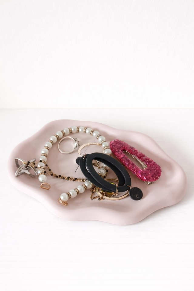 Plateau vide poche rose et plein de bijoux