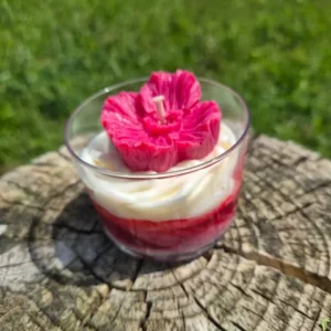Bougie artisanale en cire de soja parfumée dans un verre, avec des couches de cire blanche et rouge et une fleur rouge sur le dessus