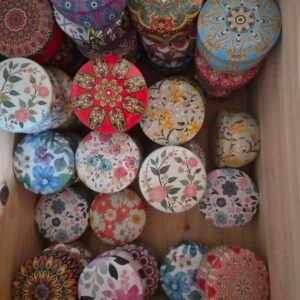 Collection de bougies parfumées artisanales dans des contenants ronds décorés de motifs floraux colorés